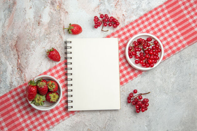 鲜花在白色桌子上俯瞰红色水果和浆果新鲜水果浆果记事本记事本水果红色水果