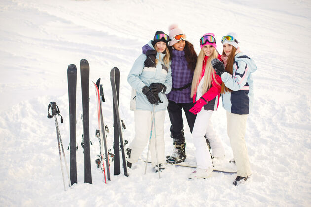 寒冷女孩们在雪地里滑雪 享受拍照的乐趣 在山上度过时光女人帽子山地