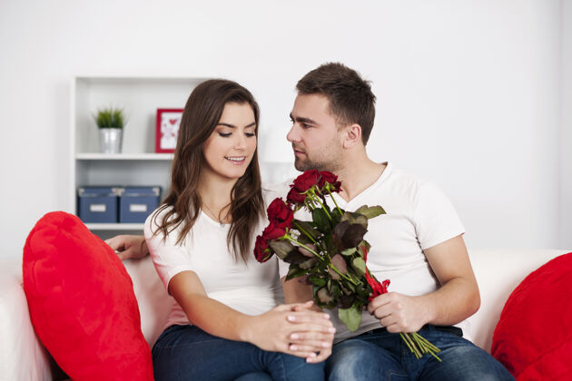 坐着红玫瑰情侣室内调情年轻夫妇