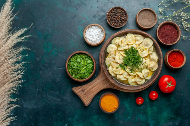肉俯瞰美味的饺子汤与不同调味料的绿色表面食物肉蔬菜面团汤不同餐厅面团