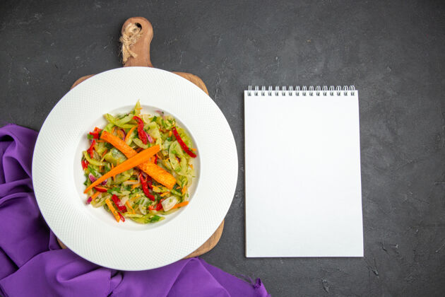 切顶部特写查看切菜板上的蔬菜沙拉紫色桌布笔记本午餐健康新鲜