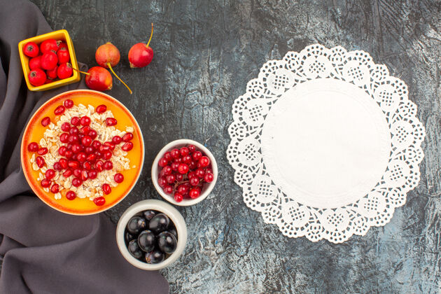 新鲜顶部特写查看浆果燕麦片与石榴彩色浆果在桌布蕾丝小饰物桌布节日季节
