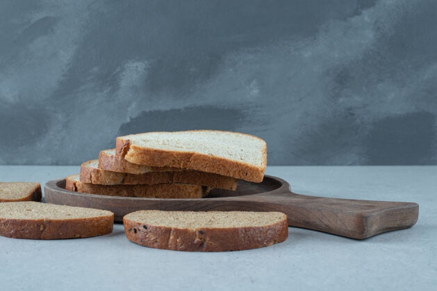 美味各种各样的面包片放在木板上健康各种食物