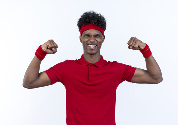 穿着快乐的年轻美国黑人运动男子戴头带和腕带做强烈的手势隔离在白色背景年轻腕带手势
