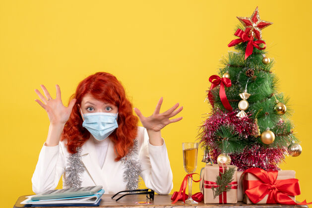 消毒前视图女医生围着圣诞树 戴着消毒口罩坐着面具礼物节日