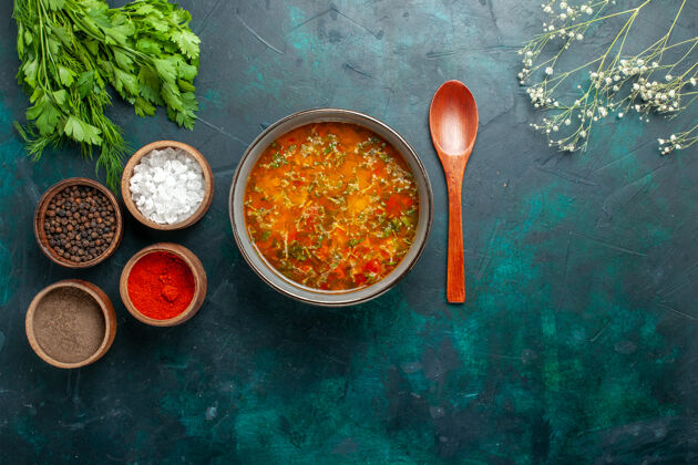 碗俯瞰美味的蔬菜汤与调味料上绿色的背景食品蔬菜配料汤产品餐视图香料膳食