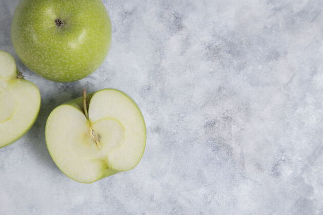 半整个和切片新鲜成熟的青苹果水果放在大理石背景上高品质的照片有机新鲜甜点