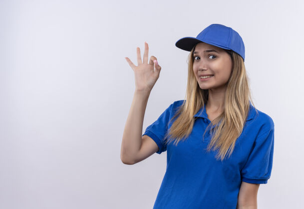年轻穿着蓝色制服 戴着帽子 在白色背景上显示出很好的姿态 并留有复印空间的关心的年轻送货女孩穿关心展示