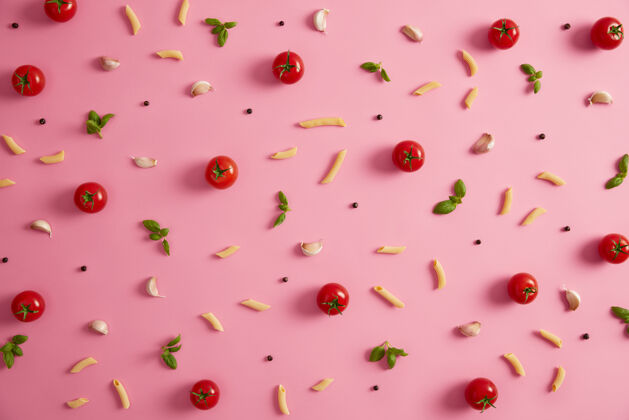 平衡粉红色背景上有潘恩麦卡龙和各种配料玫瑰色背景上有意大利面 西红柿 大蒜 胡椒均衡饮食中碳水化合物的来源是传统意大利美食的最佳选择碳水化合物课程观点
