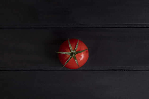 叶子一个成熟的红色番茄放在深色的木头表面高品质的照片有机成熟食物