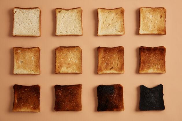 碳水化合物面包片不同程度的烤面包排成一排在米色背景下吐司或零食吃阶段的烤面包健康饮食 零食和节食的概念摄影棚照片传统块饮食