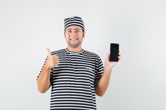 电话年轻男性手持手机 穿着t恤 戴着帽子 竖起大拇指 看上去很高兴正面图成人人成功