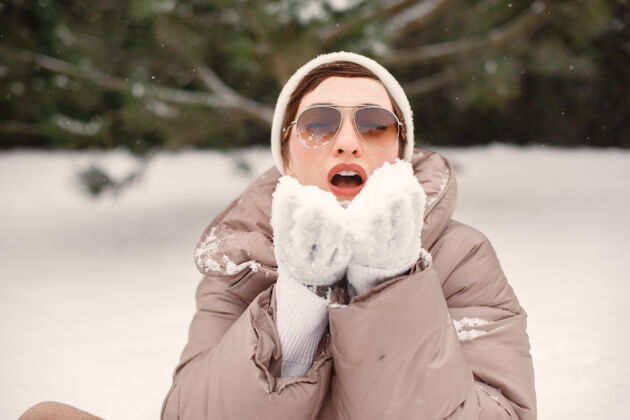 肖像雪地公园里一个穿着棕色夹克的女人的特写肖像休闲时尚雪