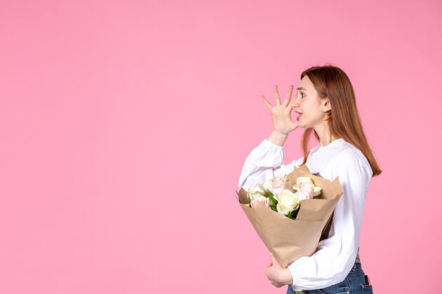 人正面图：年轻女性 带花朵 在粉色背景上呈现女性节横向女性三月爱情女性性感约会平等玫瑰花花束玫瑰