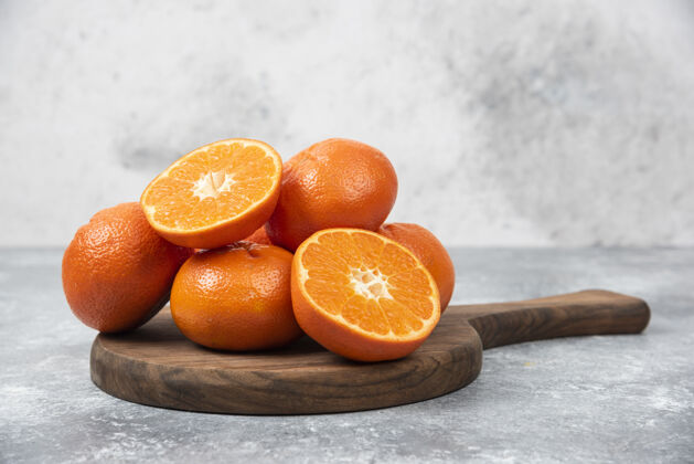 成熟石桌上摆满了橙汁水果的木板甜点圆形橙子