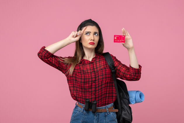 人类正面图穿着红色衬衫的年轻女性 粉色背景上有银行卡 是人类女性的颜色姿势人年轻女性