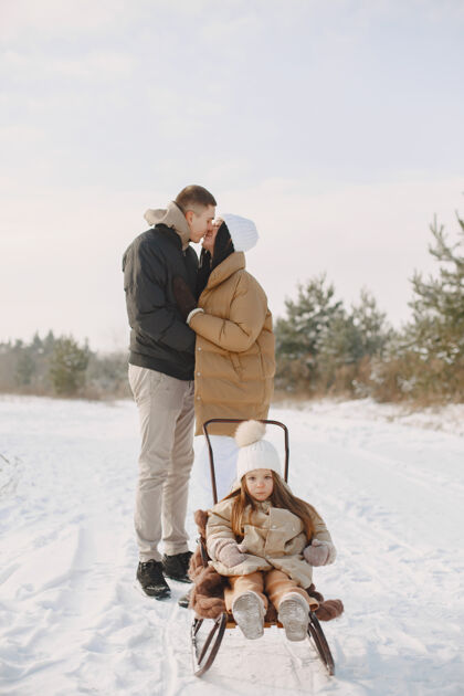女孩一家人在度假时戴着编织的冬帽自然男性童年