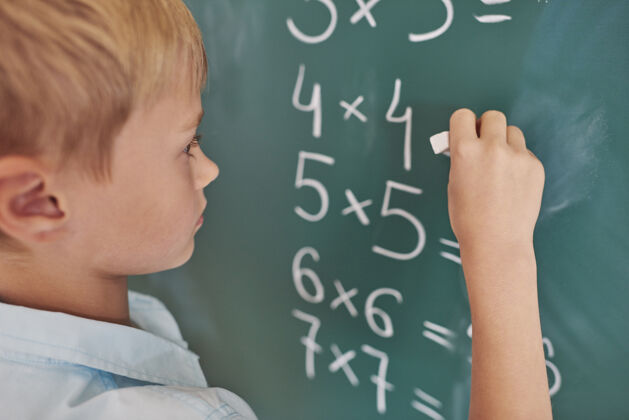 知识男孩在做数学练习智力学生站立