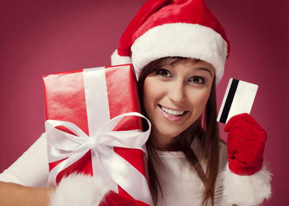 女人带着红色礼品盒和信用卡的圣诞老人圣诞老人可爱圣诞帽