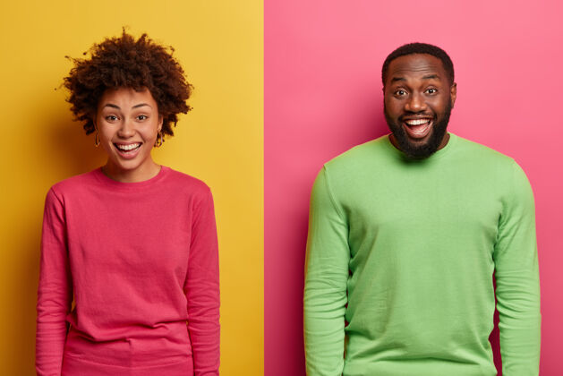 朋友这是一对笑容可掬的黑人夫妇表达积极情绪的镜头 他们穿着粉色和绿色的套头衫 享受愉快的时刻 和他们一起欢笑有趣的情景 在两面彩色的墙上摆姿势快乐休闲男孩