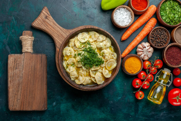 面团俯瞰美味的饺子与蔬菜和不同的调味料对深绿色桌上餐食品配料产品面团肉盘子顶部肉