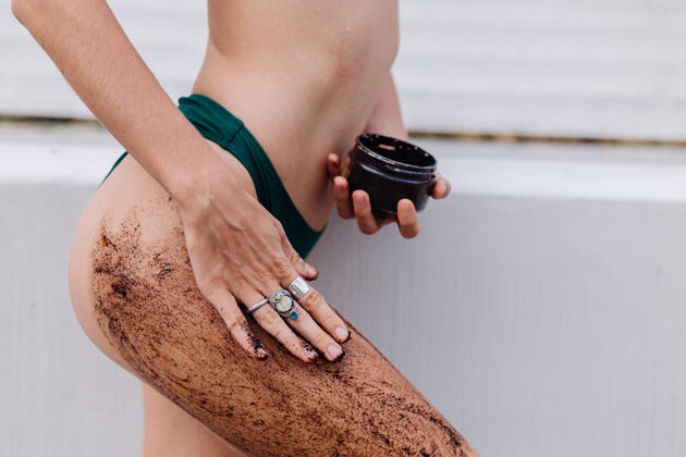 健康用咖啡擦洗身体的女人的户外照片黑色皮肤护理治疗