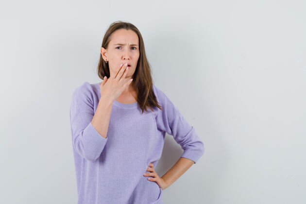 女士年轻的女性手放在嘴上 穿着淡紫色上衣 神情焦虑前视图嘴巴焦虑女性