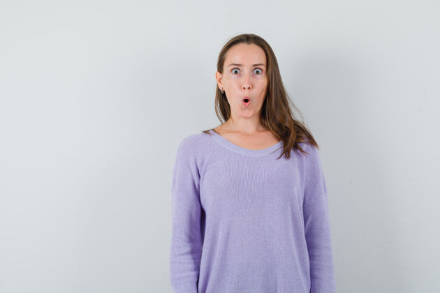 女性年轻的女人穿着淡紫色的衬衫围着她的嘴 看起来很惊讶惊喜自信性感
