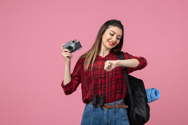 脸正面图：穿着红色衬衫的年轻女性 带相机 背景为粉色的女性模特照片漂亮黑发衬衫