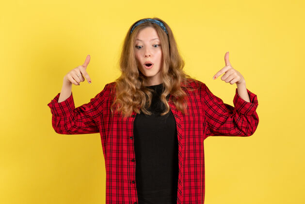 站立正面图：穿着红色格子衬衫的年轻女性 站在黄色背景上 摆姿势 女孩 人体模特成人人物年轻的女性
