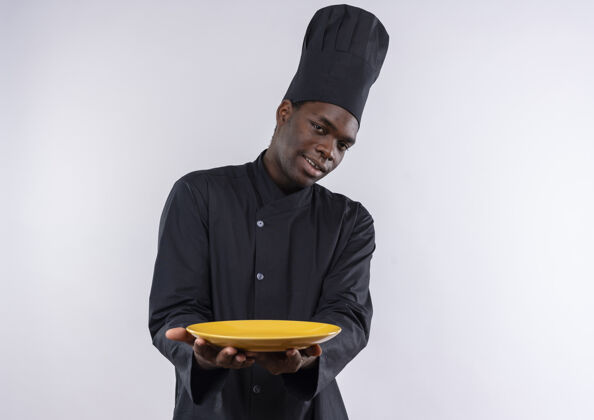 烹饪年轻的美籍黑人厨师身着厨师制服 拿着一个白色的盘子 上面留有复印空间制服盘子年轻