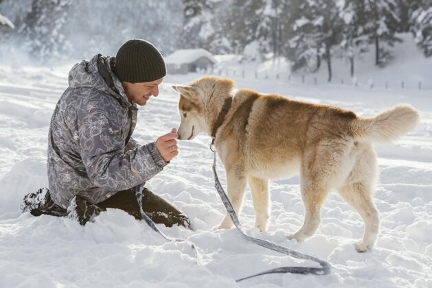冬天雪地里带着狗的全副武装的人哈士奇乐趣全拍摄