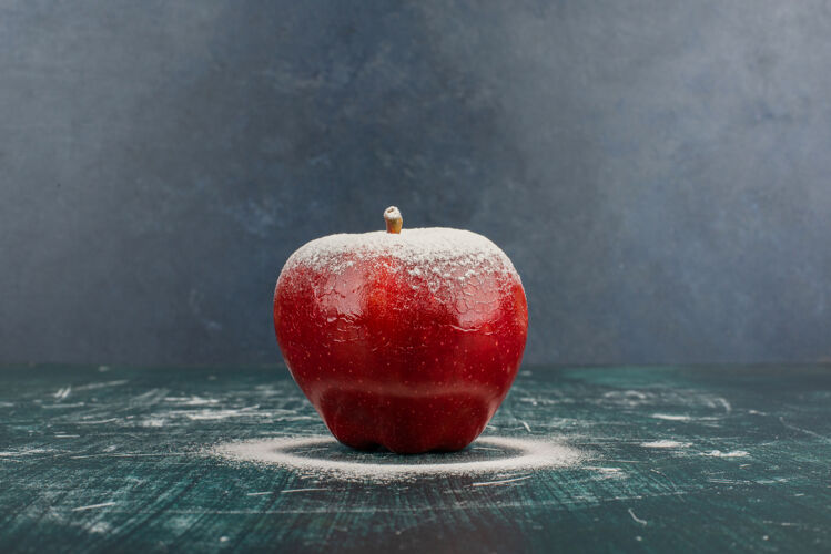 红色蓝色桌子上用粉装饰的红苹果苹果水果有机