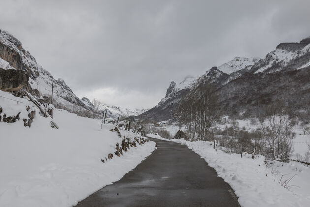 路看到一条狭窄的道路 两边都是白雪覆盖的高山窄景景