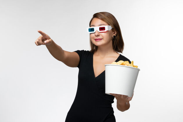 女商人正面图：年轻女性戴着d型太阳镜拿着薯片 在白色表面上看电影前面抱着孤独
