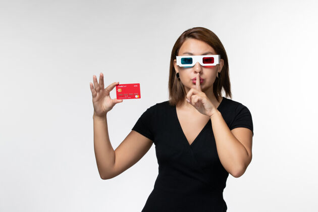 银行正面图年轻女性手持银行卡 戴着浅白色的太阳镜前面年轻女性孤独