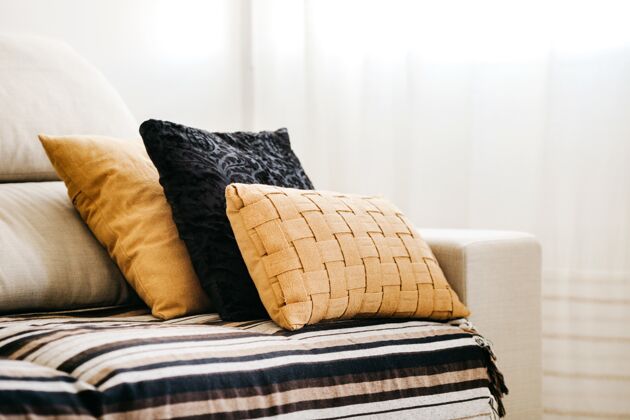 枕头白色沙发上黑色和黄色枕头的特写镜头放松家具沙发