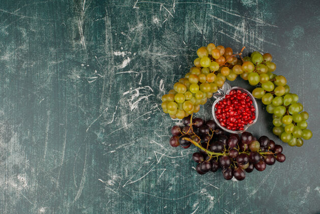 红色绿色和黑色的葡萄与石榴籽大理石表面水果美味成熟