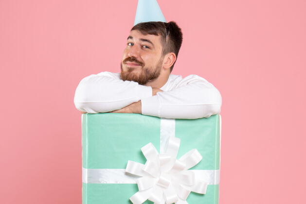 盒子正面图：年轻男性站在礼物盒内 粉色圣诞照片 彩色情感睡衣派对前面成人睡衣