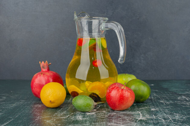 苹果把新鲜水果和果汁放在大理石桌上石榴成熟柠檬