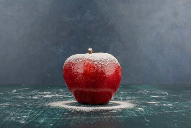 红色蓝色桌子上用粉装饰的红苹果苹果水果有机