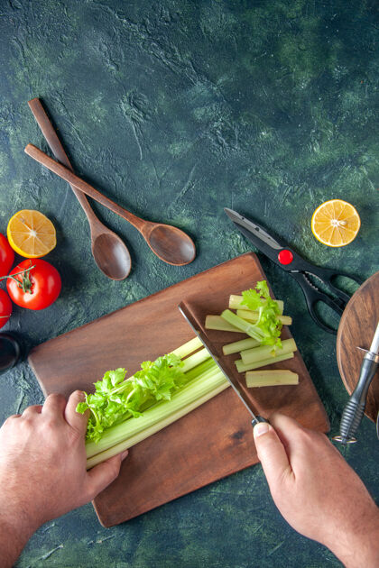 颜色顶视图男厨师切芹菜在深色餐桌上沙拉减肥餐彩色照片食物健康沙拉蔬菜膳食