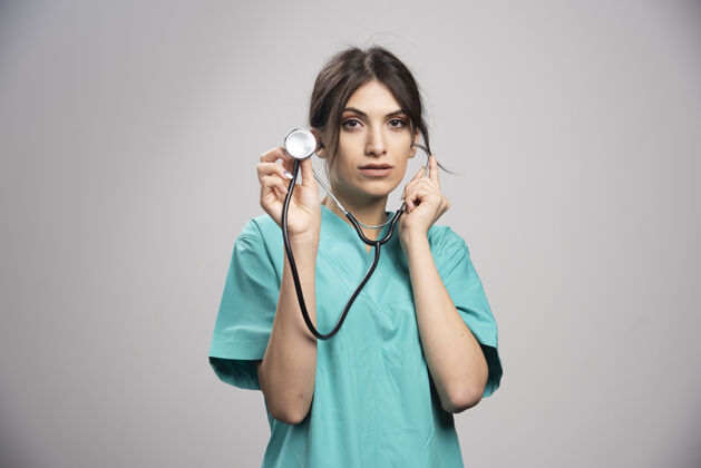 工作女医生拿着听诊器对着格雷健康疾病职业