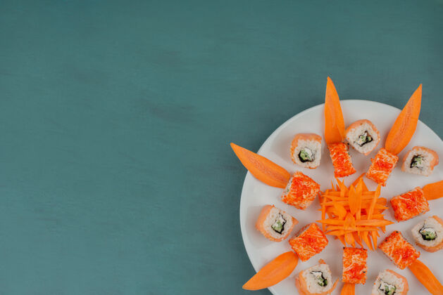 顶视图把寿司和胡萝卜片放在木板上搅拌食物海鲜切片