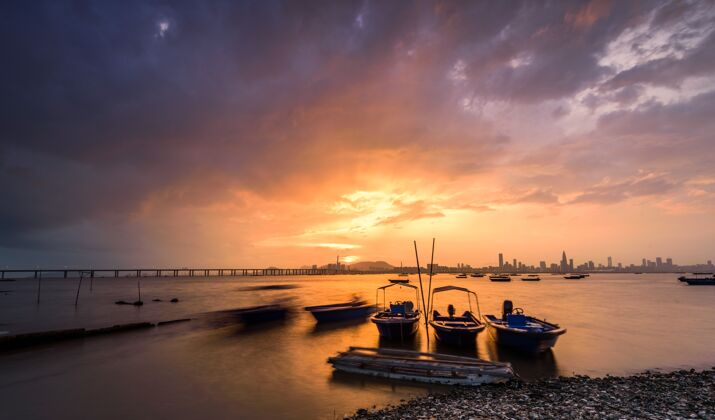 场景摩托艇停在水边 夕阳西下 一座城市清晰可见太阳白天桥