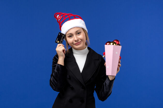 人前视图年轻女士拿着银行卡在蓝色墙上新年情感假期玩具成功成人情绪