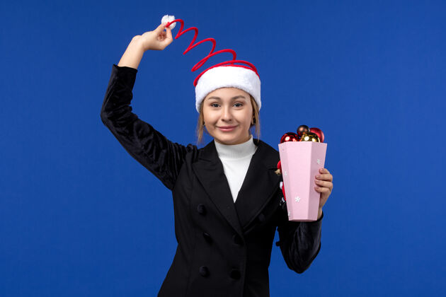 情绪前视图年轻女性与蓝色墙上的玩具树情感新年假期玩具西装商人圣诞节