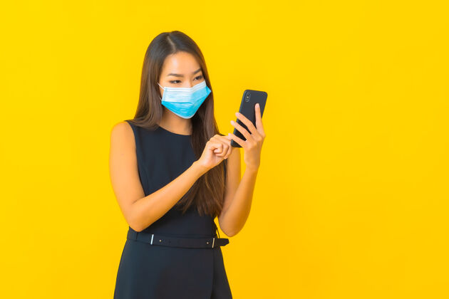 检疫肖像美丽的年轻亚洲女商人戴上口罩保护covid19和使用手机2019ncov呼吸手机