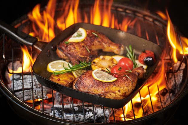 西红柿在火焰烤架上烤鸡腿 配上烤蔬菜 西红柿 土豆 胡椒籽 盐薯条热家禽