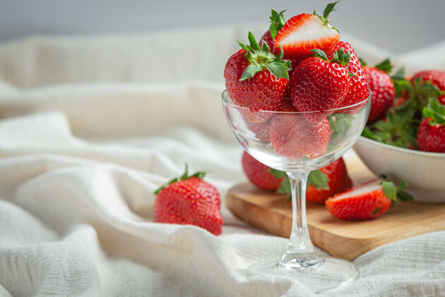 切片新鲜草莓放在木桌上的玻璃杯里美味市场餐巾